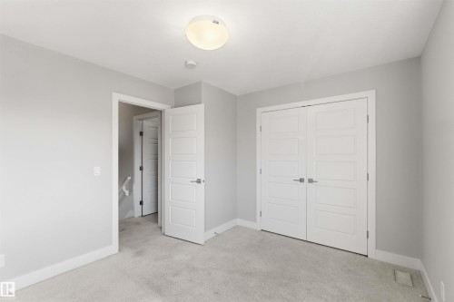Recessed ceiling light fixture, white interior doors, gray wall finish, white trim, and gray carpet flooring - 7 Mclean Court, Leduc, AB - Indoor Photo Showing Other Room