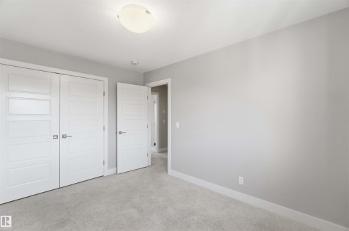 Plush carpet flooring, light gray wall finishes, contemporary white interior doors, and a flush mount ceiling light fixture - 7 Mclean Court, Leduc, AB - Indoor Photo Showing Other Room