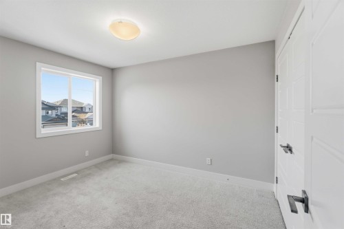 Light gray wall finish, white trim, carpeted flooring, and a flush-mount ceiling light fixture - 7 Mclean Court, Leduc, AB - Indoor Photo Showing Other Room