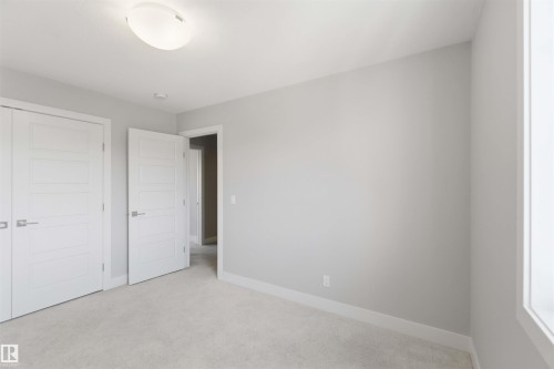Recessed panel doors, soft gray wall paint, light-colored carpeting, white trim, and a semi-flush mount ceiling light - 7 Mclean Court, Leduc, AB - Indoor Photo Showing Other Room