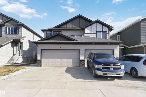 Two-story home with a two-car garage, concrete driveway, and stone accent pillars - 7 Mclean Court, Leduc, AB - Outdoor With Facade