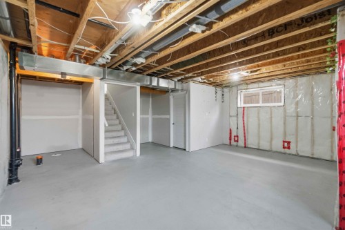 Unfinished basement with exposed ceiling joists, concrete flooring, and a window - 7 Mclean Court, Leduc, AB - Indoor Photo Showing Basement
