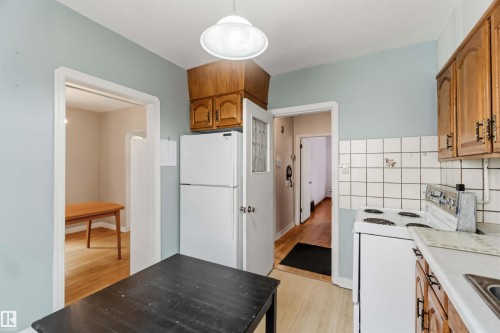 Kitchen with light blue walls, wood-finish flooring, and wood cabinetry - 11710 94 Street Nw, Edmonton, AB - Indoor Photo Showing Kitchen