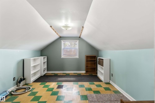 Sloped ceilings with recessed lighting, central window, and patterned flooring - 11710 94 Street Nw, Edmonton, AB - Indoor
