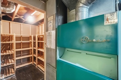Storage space featuring wood shelving and exposed ceiling joists - 11710 94 Street Nw, Edmonton, AB - Indoor