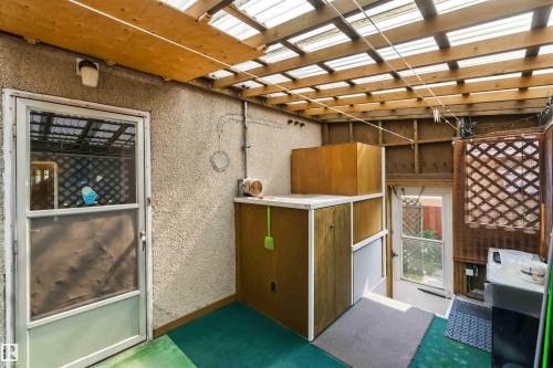 Enclosed outdoor space with a translucent panel roof, exposed wood beam ceiling, and a textured stucco wall - 11710 94 Street Nw, Edmonton, AB - Indoor