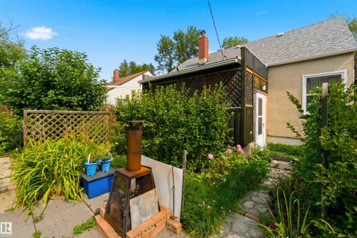 Backyard featuring a stone paver path, mature landscaping, and a lattice privacy screen - 11710 94 Street Nw, Edmonton, AB - Outdoor