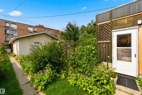 Detached structure with a white entry door, lattice detailing, and a concrete pathway - 11710 94 Street Nw, Edmonton, AB - Outdoor