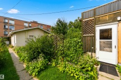 Detached structure with a white entry door, lattice detailing, and a concrete pathway - 