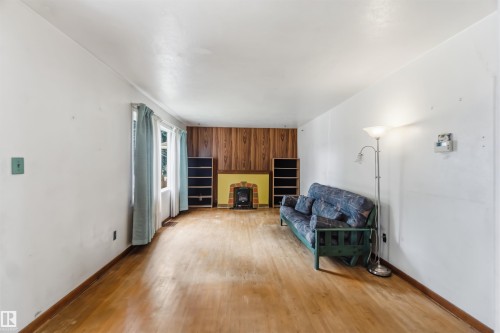 Spacious recreation room featuring hardwood flooring, white walls, and abundant natural light from multiple windows - 11710 94 Street Nw, Edmonton, AB - Indoor