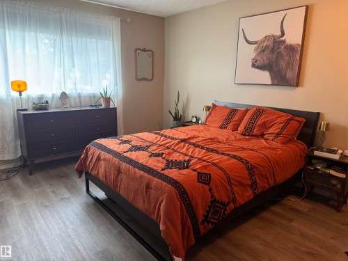 Wood-finish flooring throughout the room - #38 8930 99 Av, Fort Saskatchewan, AB - Indoor Photo Showing Bedroom