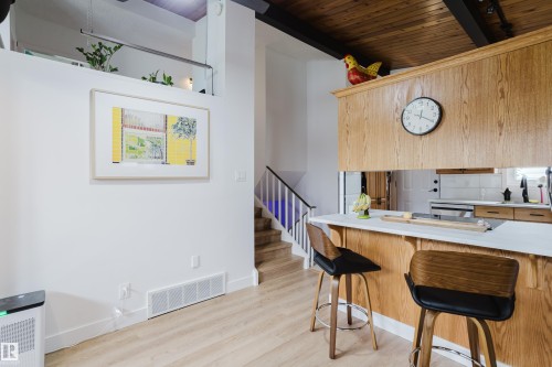 Wood-finish flooring, wood plank ceiling, light wood cabinetry, white countertops, and open concept design - 9059 52 Street Nw, Edmonton, AB - Indoor