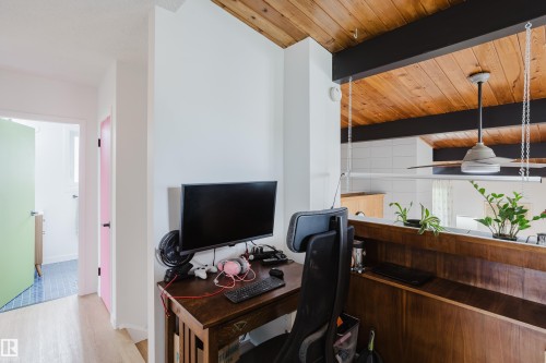 Wood-finish vaulted ceiling with exposed beams, wood-finish flooring, and a built-in wood-finish half-wall - 9059 52 Street Nw, Edmonton, AB - Indoor Photo Showing Office
