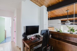 Wood-finish vaulted ceiling with exposed beams, wood-finish flooring, and a built-in wood-finish half-wall - 