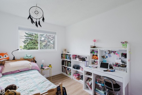 White walls with light wood-finish flooring - 9059 52 Street Nw, Edmonton, AB - Indoor Photo Showing Bedroom