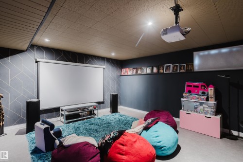 Media room featuring a drop ceiling with recessed lighting, a mounted projector, and a pull-down screen - 9059 52 Street Nw, Edmonton, AB - Indoor