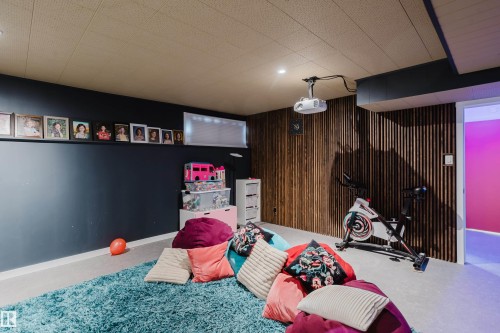 Recessed lighting, wood-panel accent wall, projector with ceiling mount, and drop ceiling with integrated lighting - 9059 52 Street Nw, Edmonton, AB - Indoor