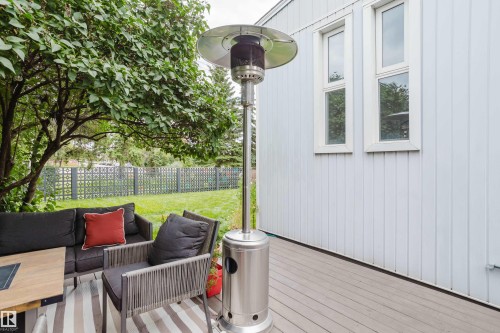 Expansive outdoor deck with a private yard, mature landscaping, and decorative fencing - 9059 52 Street Nw, Edmonton, AB - Outdoor With Exterior