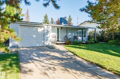 Single-story residence featuring a white garage door, covered porch, and a concrete driveway - 9059 52 Street Nw, Edmonton, AB - Outdoor