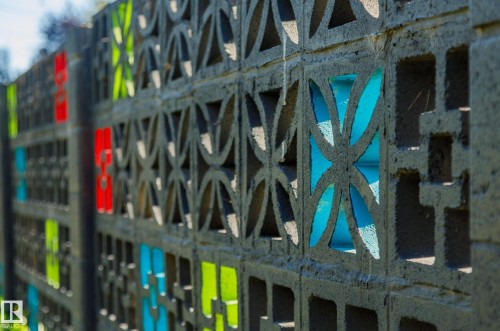 Decorative concrete block wall featuring geometric patterns and colored translucent inserts - 9059 52 Street Nw, Edmonton, AB - Outdoor