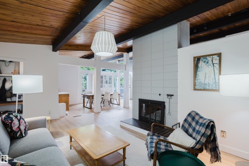 Vaulted wood-paneled ceiling with exposed beams, tiled fireplace surround, and wood-finish flooring - 9059 52 Street Nw, Edmonton, AB - Indoor Photo Showing Living Room With Fireplace