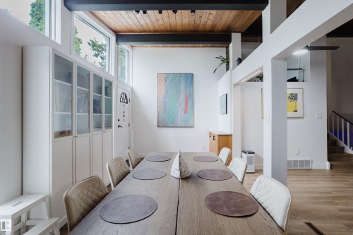 Vaulted wood-paneled ceiling with exposed structural beams, built-in display cabinetry, clerestory windows, and light wood-finish flooring - 9059 52 Street Nw, Edmonton, AB - Indoor Photo Showing Dining Room