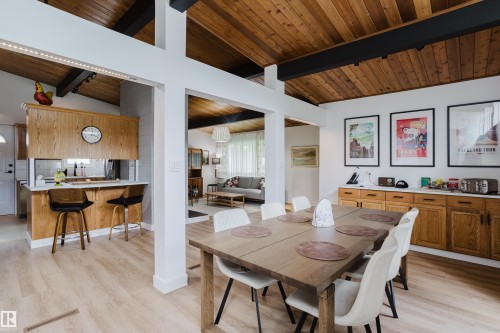 Vaulted wood-paneled ceilings with exposed beams, wood-finish flooring, and a dining area with built-in cabinetry featuring white countertops - 9059 52 Street Nw, Edmonton, AB - Indoor Photo Showing Dining Room
