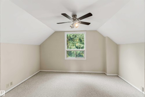 Vaulted ceiling room with a central window, featuring light-toned carpeting and neutral wall paint - 12243 104 Street Nw, Edmonton, AB - Indoor Photo Showing Other Room