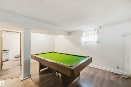 Finished lower level featuring recessed window, wood-finish flooring, and a neutral color palette - 12243 104 Street Nw, Edmonton, AB - Indoor Photo Showing Other Room