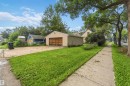 Detached garage with a wood-finish overhead door, concrete driveway, and a front lawn - 12243 104 Street Nw, Edmonton, AB  - Outdoor 