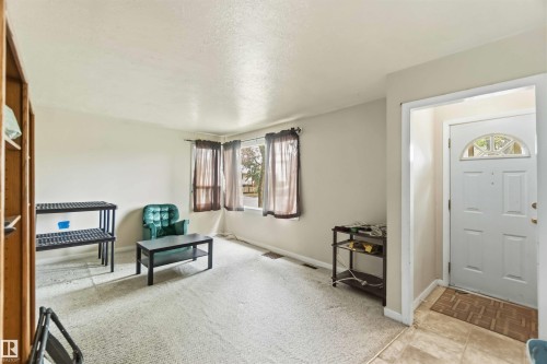 Inviting entry area with a white paneled door featuring a decorative arched window - 12243 104 Street Nw, Edmonton, AB - Indoor Photo Showing Other Room