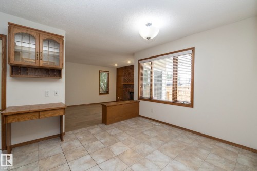 Tiled flooring, wood-framed window, built-in cabinetry with glass inserts, wood-finish flooring, and recessed lighting - 11138 30 Avenue Nw, Edmonton, AB - Indoor Photo Showing Other Room