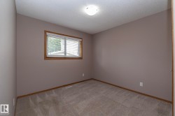 Neutral wall color, wall-to-wall carpeting, wood-trim window with blinds, and flush mount lighting - 