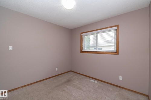 Neutral tone walls with wood trim window, flush mount ceiling light, and carpet flooring - 11138 30 Avenue Nw, Edmonton, AB - Indoor Photo Showing Other Room