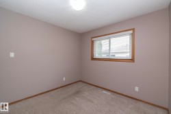 Neutral tone walls with wood trim window, flush mount ceiling light, and carpet flooring - 