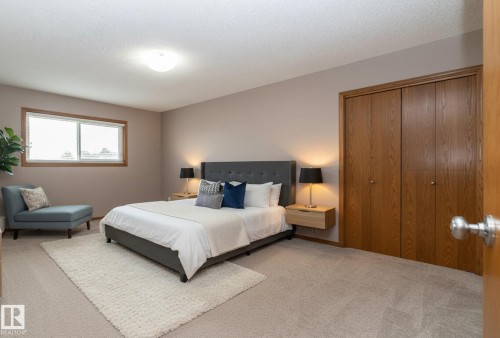 Hardwood-frame window with blinds, light-toned wall paint, neutral carpet flooring, and bi-fold wood closet doors - 11138 30 Avenue Nw, Edmonton, AB - Indoor Photo Showing Bedroom
