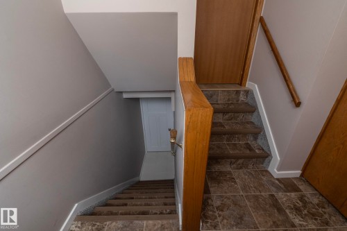 Tile flooring, wood-finish handrail, and painted walls - 11138 30 Avenue Nw, Edmonton, AB - Indoor Photo Showing Other Room
