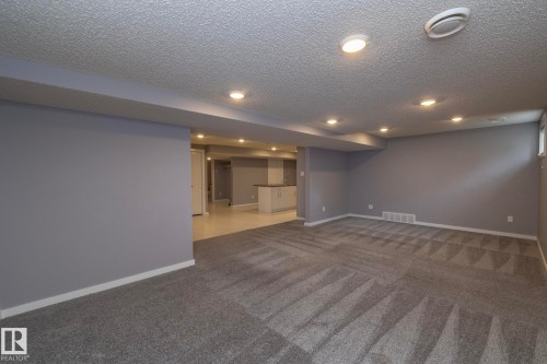 Recessed lighting illuminates the carpeted living area and tiled entry - 11138 30 Avenue Nw, Edmonton, AB - Indoor Photo Showing Other Room