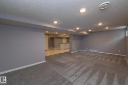 Recessed lighting illuminates the carpeted living area and tiled entry - 