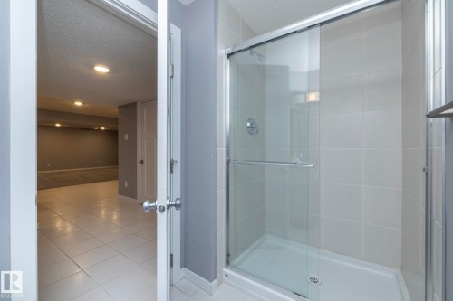 Shower with sliding glass enclosure, white tile surround, and chrome fixtures - 11138 30 Avenue Nw, Edmonton, AB - Indoor Photo Showing Bathroom
