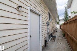 Siding exterior with multiple windows, a rear entry door, and concrete walkway - 
