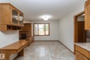 Built-in oak cabinetry with glass doors, integrated desk, tile flooring, and a window with wood blinds - 11138 30 Avenue Nw, Edmonton, AB  - Indoor With Fireplace 