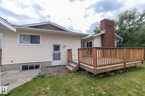 Exterior featuring wood siding, a red brick chimney, and a raised wood deck with railing - 11138 30 Avenue Nw, Edmonton, AB - Outdoor With Exterior