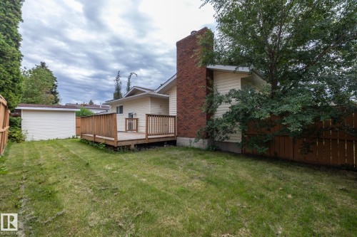 Expansive lawn area with a wood deck, brick chimney, and a detached shed - 11138 30 Avenue Nw, Edmonton, AB - Outdoor