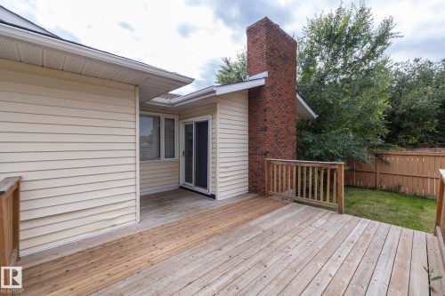 Expansive wood deck with wood railing, brick chimney, and sliding glass door - 11138 30 Avenue Nw, Edmonton, AB - Outdoor With Exterior