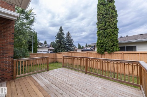 Expansive wood deck with wood railings, featuring a brick exterior wall and a wood privacy fence - 11138 30 Avenue Nw, Edmonton, AB - Outdoor