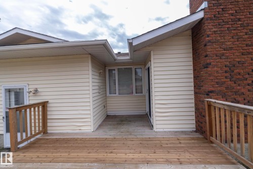 Wood deck with timber railings, exterior siding, and brick chimney - 11138 30 Avenue Nw, Edmonton, AB - Outdoor With Exterior