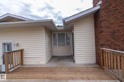 Wood deck with timber railings, exterior siding, and brick chimney - 
