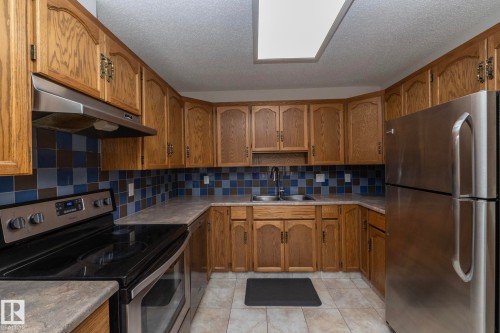 Kitchen featuring wood cabinetry, stainless steel appliances, a tiled backsplash, and recessed lighting - 11138 30 Avenue Nw, Edmonton, AB - Indoor Photo Showing Kitchen With Stainless Steel Kitchen