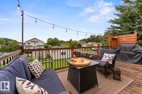 Expansive wooden deck with a black metal railing, string lighting, and an integrated privacy screen - 5330 43 Street, Cold Lake, AB - Outdoor With Deck Patio Veranda With Exterior